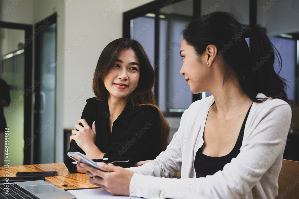 Two businesswomen colleagues sitting together in office. Two businesswomen colleagues sitting together in office.
