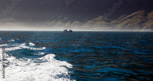 Sea surface with ship going in haze along the coast.