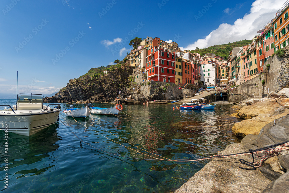 The famous Riomaggiore village with small boats moored in the port, Cinque Terre National Park in Liguria, La Spezia, Italy, Europe. UNESCO world heritage site.