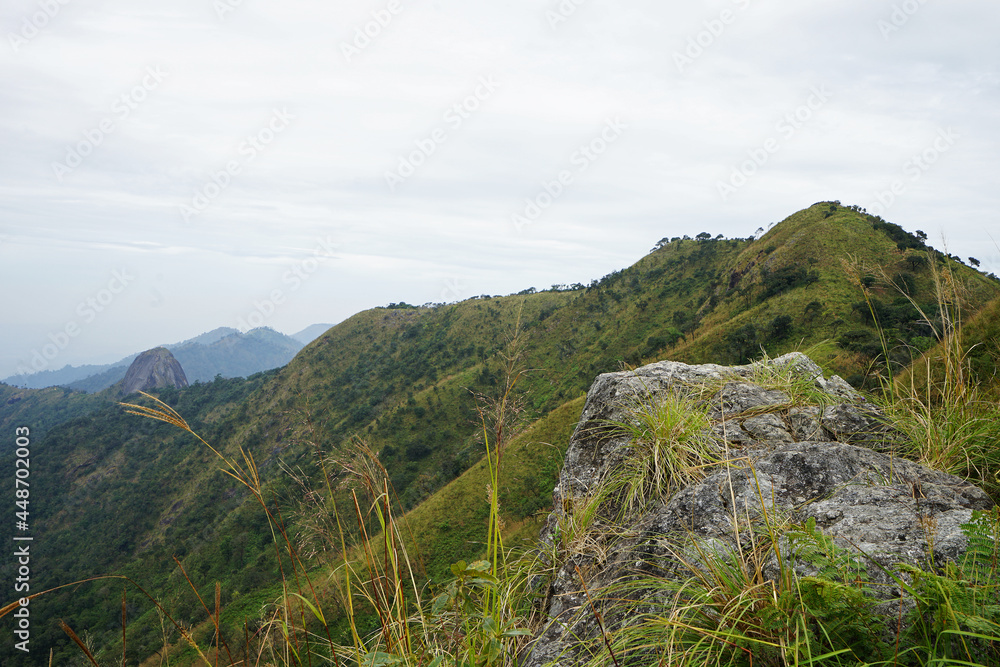 Natural landscape of green mountain range with cloudy blue sky Natural landscape of green mountain range with cloudy blue sky