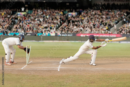 Batsman is Stumped by Wicket Keeper During a match in the stadium photo