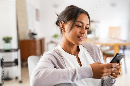 African mid woman using smartphone at home