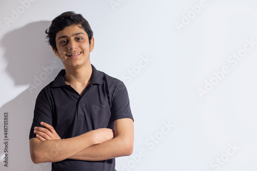 PORTRAIT OF A HAPPY TEENAGE BOY LOOKING AT CAMERA AND POSING