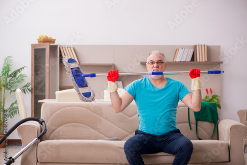 Old man cleaning the house