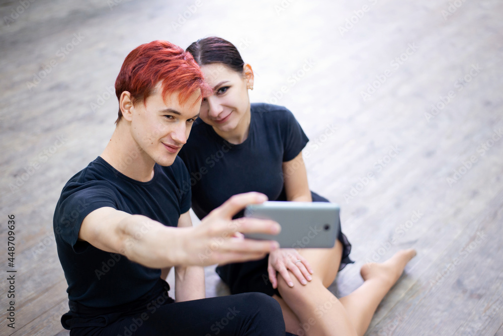 Pair of dancers taking selfie on the mobile phone after the training. Male and female dancers having fun, relaxing after a long and exhausting dancing learning