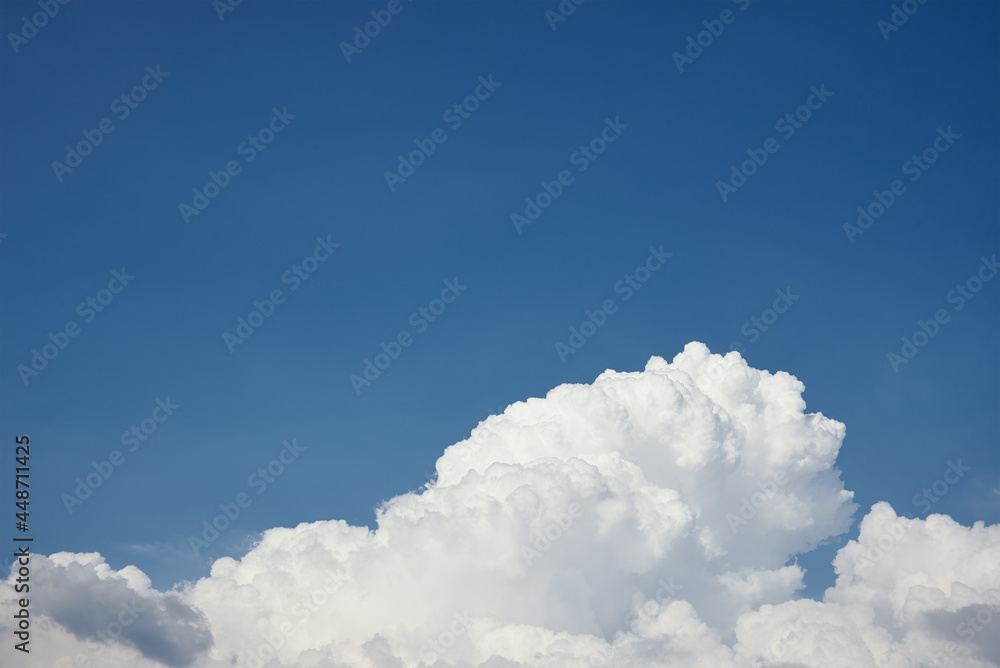 Big white fluffy clouds on clear blue sky. Cloudy sky background with copy space. Cumulus cloud close up Big white fluffy clouds on clear blue sky. Cloudy sky background with copy space. Cumulus cloud close up