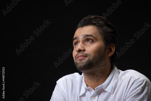 Portrait of a young man smiling while thinking something.