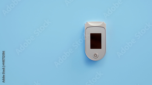 Portable Pulse oximeter isolated on blue background. Medical device for hypoxia