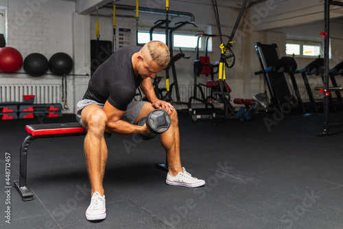 Wallpaper Mural Young athlete Working out biceps at the gym.Closeup muscular young man lifting weights in gym on a dark background. Torontodigital.ca