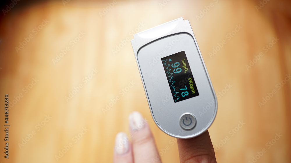 Pulse oximeter on finger showing oxygen saturation and heart rate. Prevention of hypoxia in pneumonia Pulse oximeter on finger showing oxygen saturation and heart rate. Prevention of hypoxia in pneumonia