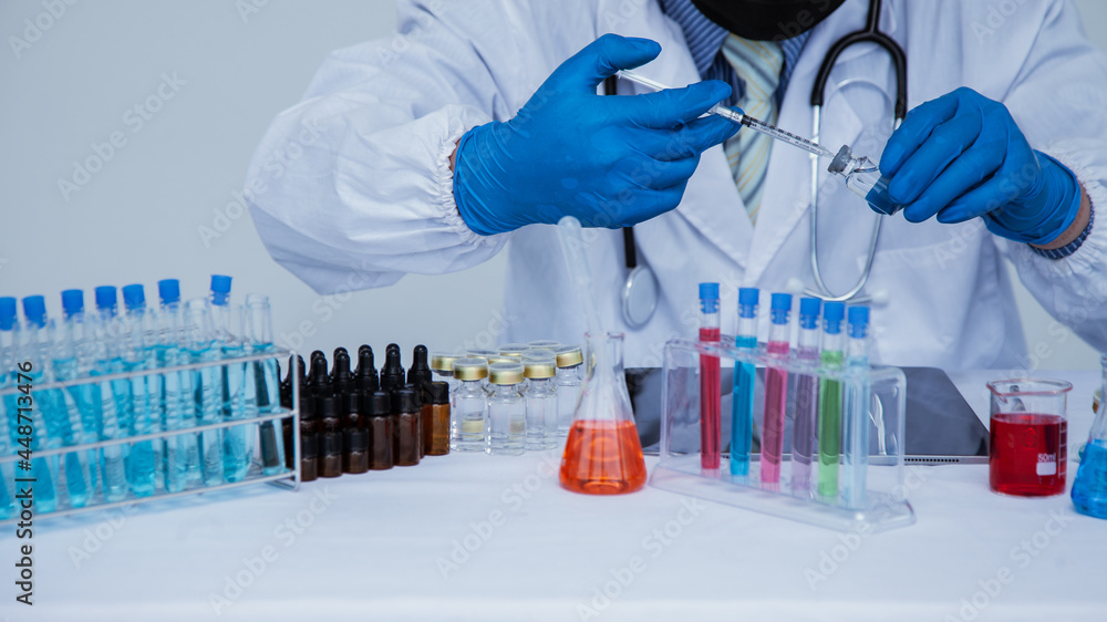 medical or scientific researcher researching and experimenting Multi-colored solution, vial and microscope In the laboratory or in the laboratory by wearing blue gloves and white clothing completely. medical or scientific researcher researching and experimenting Multi-colored solution, vial and microscope In the laboratory or in the laboratory by wearing blue gloves and white clothing completely.