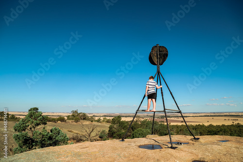 Boy exploring rocky hill top at the Terrick Terrick National Park near Mitiamo, Victoria Australia photo