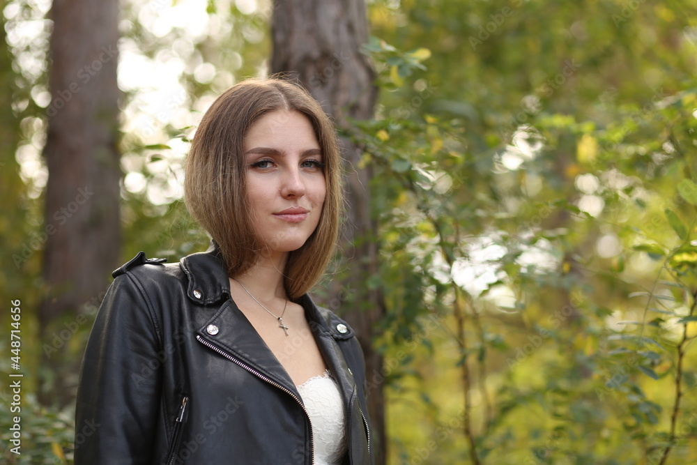 Portrait of towheaded young woman in leather jacket in the forest Portrait of towheaded young woman in leather jacket in the forest