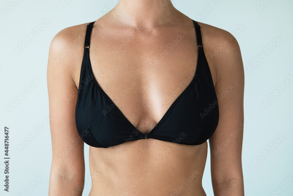 Woman with natural breast wearing black swimwear top