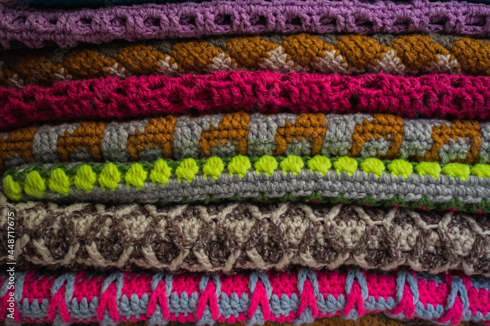A stack of crocheted bags with different patterns and different colors. A stack of crocheted bags with different patterns and different colors.