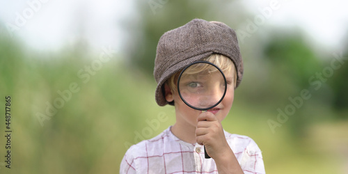 neugieriger Junge mit Lupe