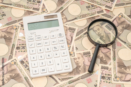 Many Japanese 10000 yen bills, calculators and magnifying glass