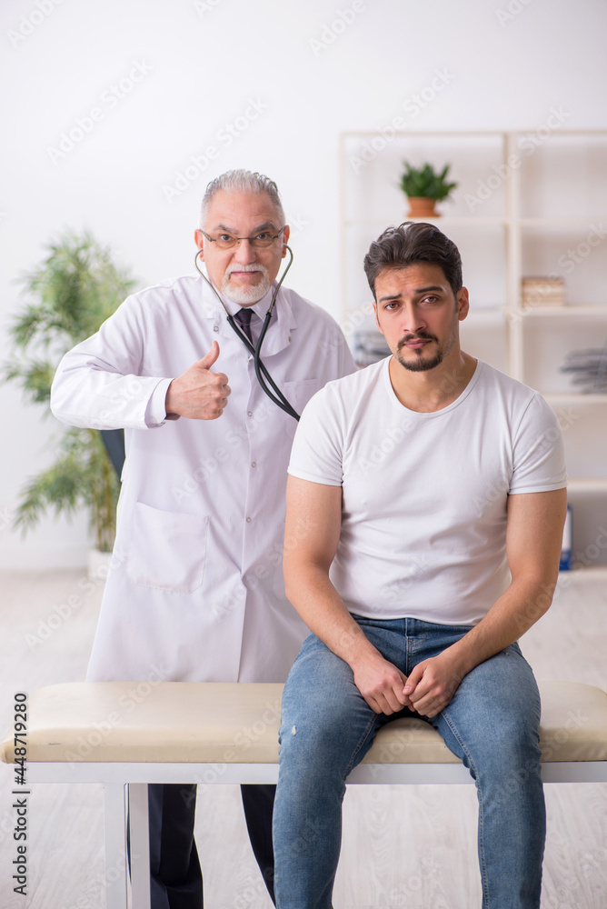 Young male patient visiting old male doctor Young male patient visiting old male doctor
