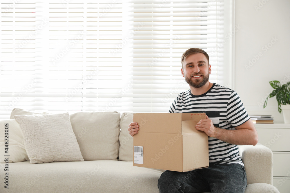 Happy young man with parcel at home Happy young man with parcel at home