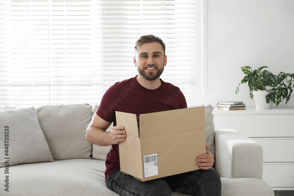 Happy young man with parcel at home Happy young man with parcel at home