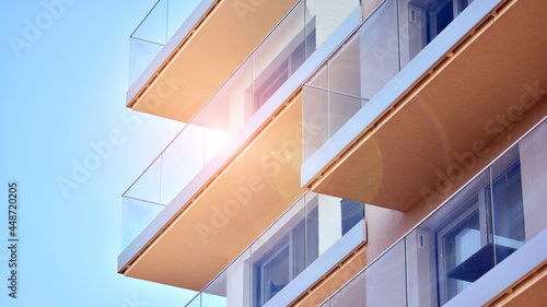 New apartment building with glass balconies. Modern architecture houses by the sea. Large glazing on the facade of the building.