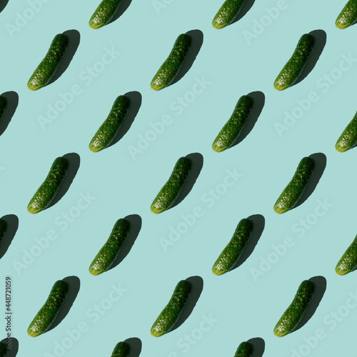 Fresh cucumbers on a blue background. Pattern of cucumbers. Top view. Banner. Pop art design, creative summer food concept. Green cucumbers, minimal flat lay style.