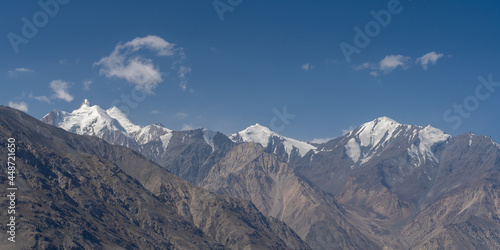 Scenic panoramic view on snow capped Hindu Kush mountain range peaks on Afghanistan side of Wakhan corridor, Gorno-Badakshan, Tajikistan