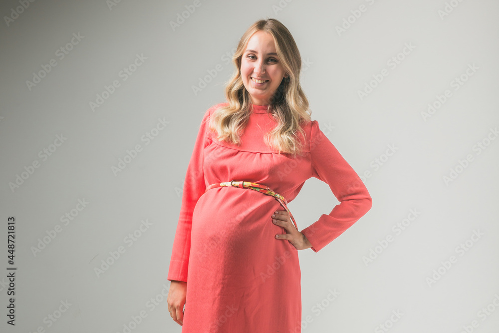 Pregnant woman on white wall background, space for text Pregnant woman on white wall background, space for text