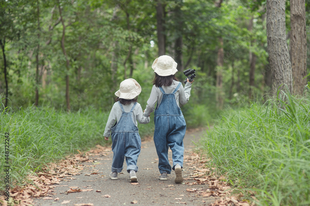 Children are heading to the family campsite in the forest Walk along the tourist route. Camping road. Family travel vacation concept. Children are heading to the family campsite in the forest Walk along the tourist route. Camping road. Family travel vacation concept.