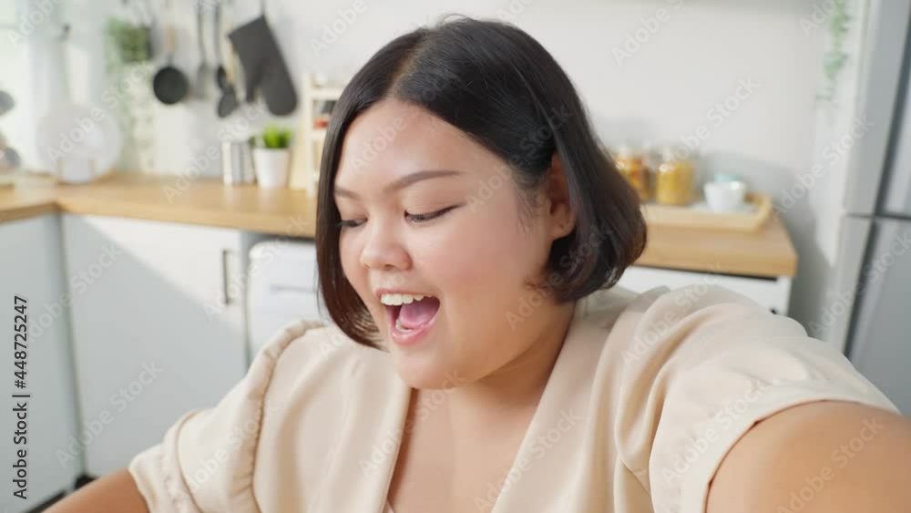 Asian oversize vlogger big woman eat unhealthy food in kitchen at home Asian oversize vlogger big woman eat unhealthy food in kitchen at home