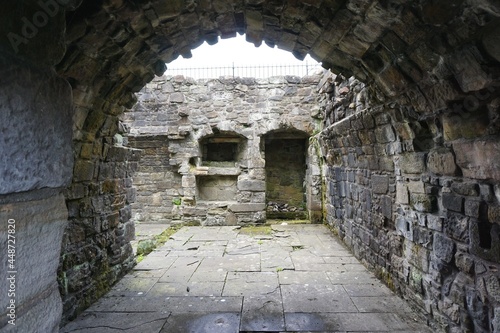 Looking into the remnants of an ancient stone fortress ruin in a rural European village