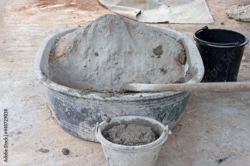 Cement and hoe in plastic bucket  for mixer in construction site. © Pannarai