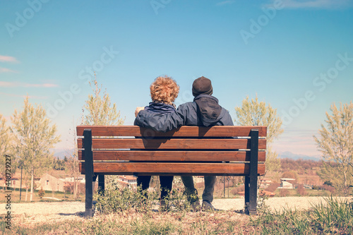 Old lovers on a bench. Couple enjoying together the nature (they resting in a park)