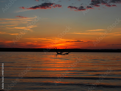 Summer sunset on the Kama river. Driftwood in the water. Beautiful clouds. Russia, Ural, Perm Territory, Elovo. © Max G K