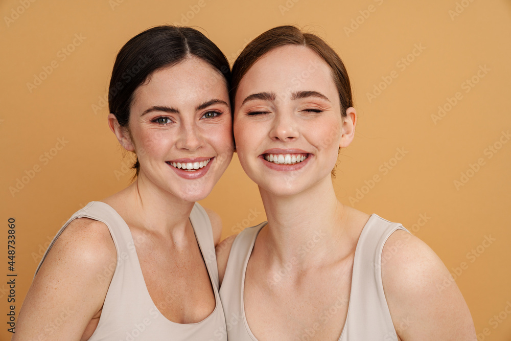 Young two women in undershirt looking and smiling at camera Young two women in undershirt looking and smiling at camera
