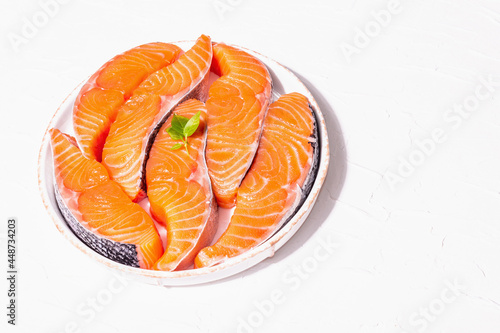 Fresh raw salmon or trout fish fillet steaks. Minimalistic design, modern hard light, dark shadow