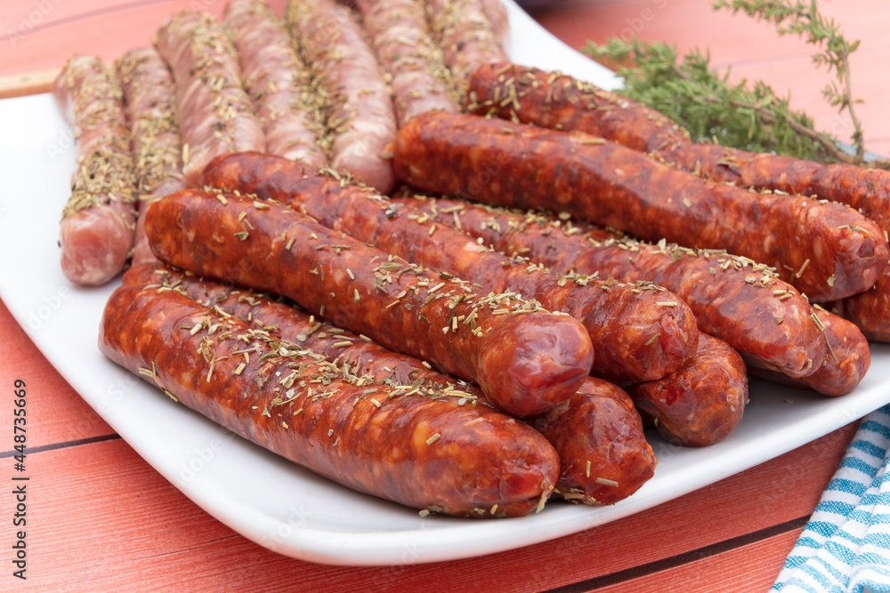 saucisses et merguez crues dans une assiette