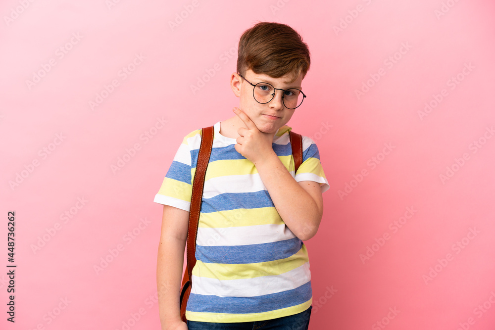 Little redhead caucasian boy isolated on pink background thinking Little redhead caucasian boy isolated on pink background thinking