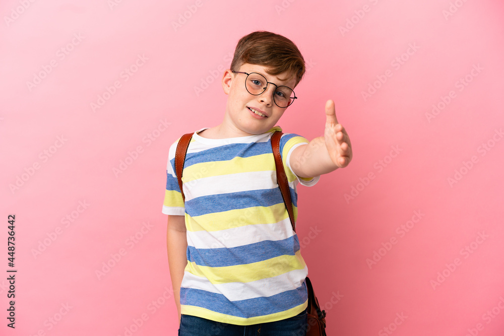 Little redhead caucasian boy isolated on pink background shaking hands for closing a good deal Little redhead caucasian boy isolated on pink background shaking hands for closing a good deal