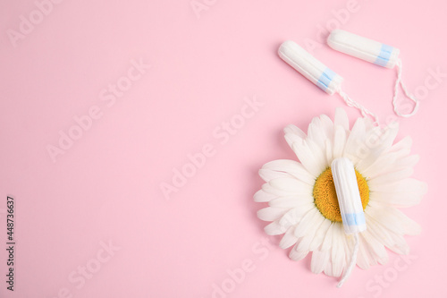 Tampons and chamomile on light pink background  flat lay. Space for text