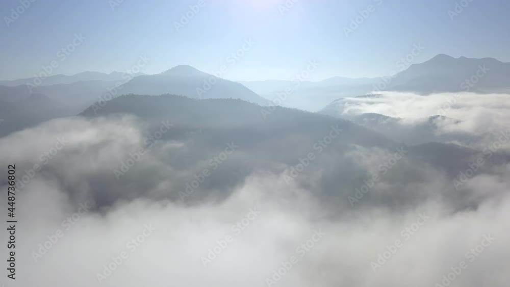 Aerial view pan camera over the sea of clouds coverage the mountains peak during beautiful morning sunlight at Mae Hong Son province, amazing travel destination of northern Thailand. Aerial view pan camera over the sea of clouds coverage the mountains peak during beautiful morning sunlight at Mae Hong Son province, amazing travel destination of northern Thailand.