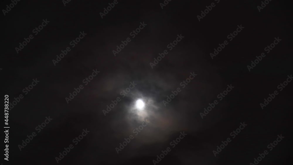 Fast moving clouds passing in front of the moon at night. Mystery fairyland scene. Fast moving clouds passing in front of the moon at night. Mystery fairyland scene.