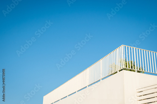 White terrace with metal railing under blue sky