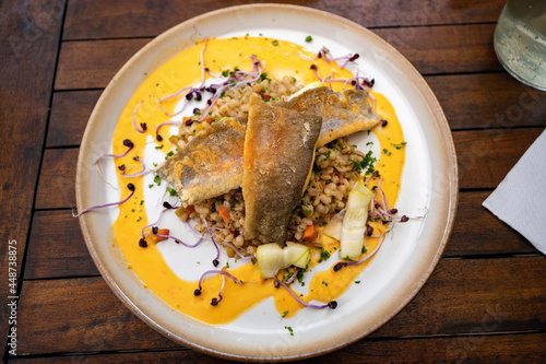 Zander fillet with barley groat, zucchini, carrot, sprout and mustard sauce. photo