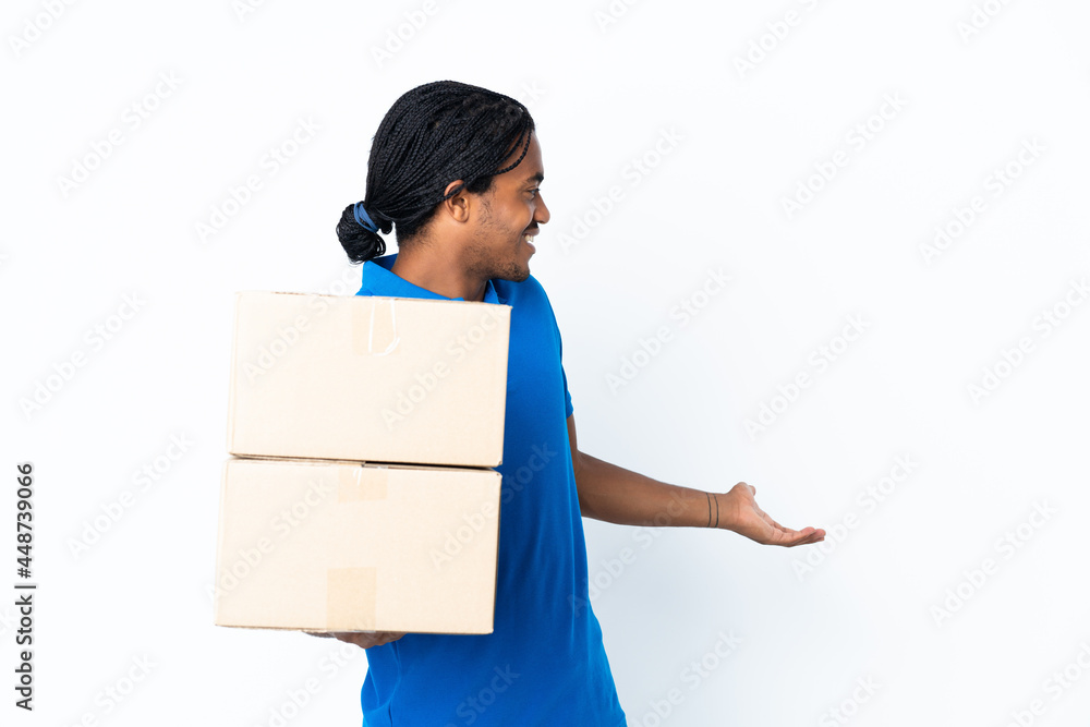 Delivery African American man with braids isolated on white background with surprise expression while looking side Delivery African American man with braids isolated on white background with surprise expression while looking side