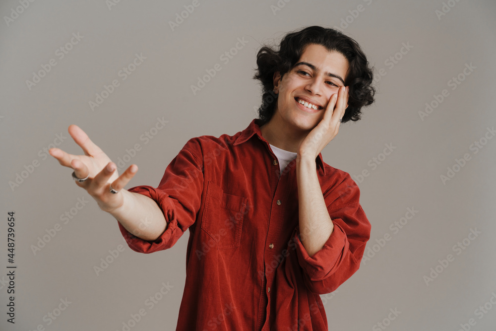 Young brunette man in red shirt smiling and looking aside Young brunette man in red shirt smiling and looking aside