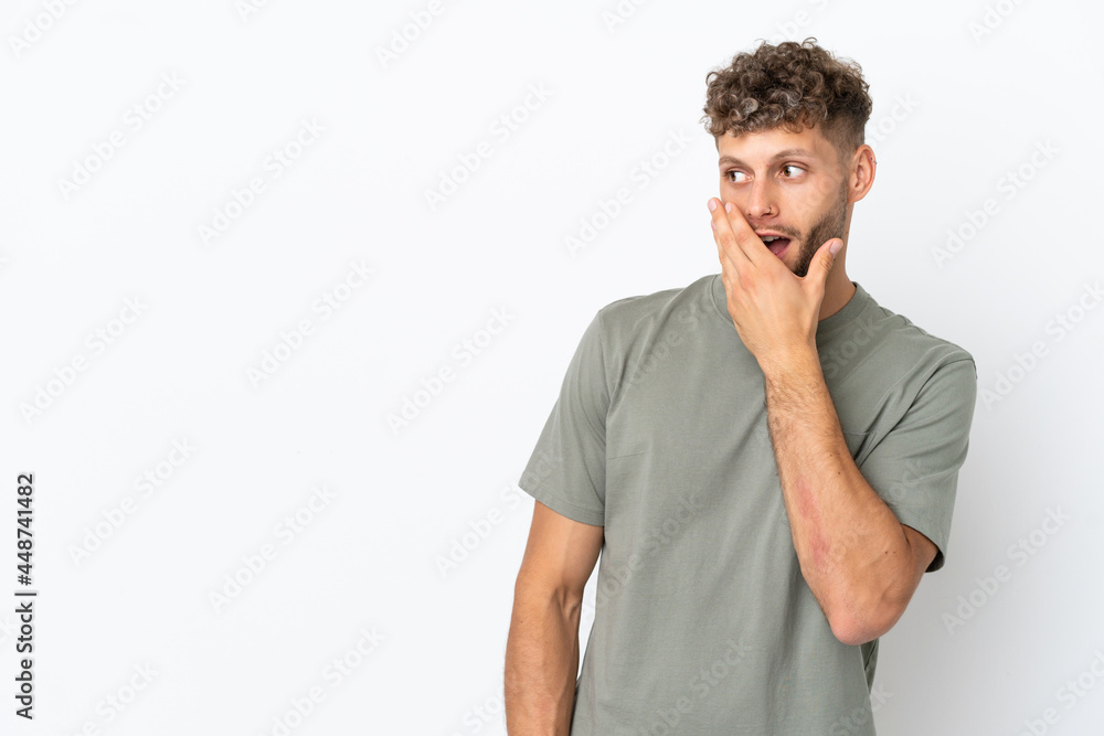 Young caucasian handsome man isolated on white background doing surprise gesture while looking to the side Young caucasian handsome man isolated on white background doing surprise gesture while looking to the side