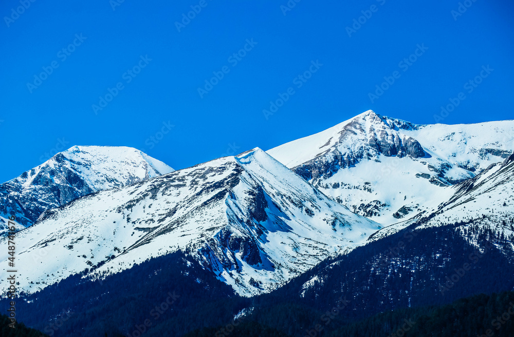 Fototapeta premium Mountain snow peak, beautiful natural winter backdrop. Ice top of the hill, blue sky background. Alpine landscape.