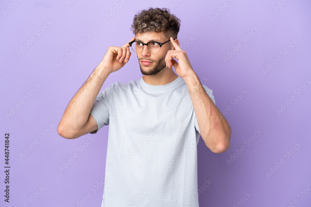 Delivery caucasian man isolated on purple background having doubts and thinking Delivery caucasian man isolated on purple background having doubts and thinking