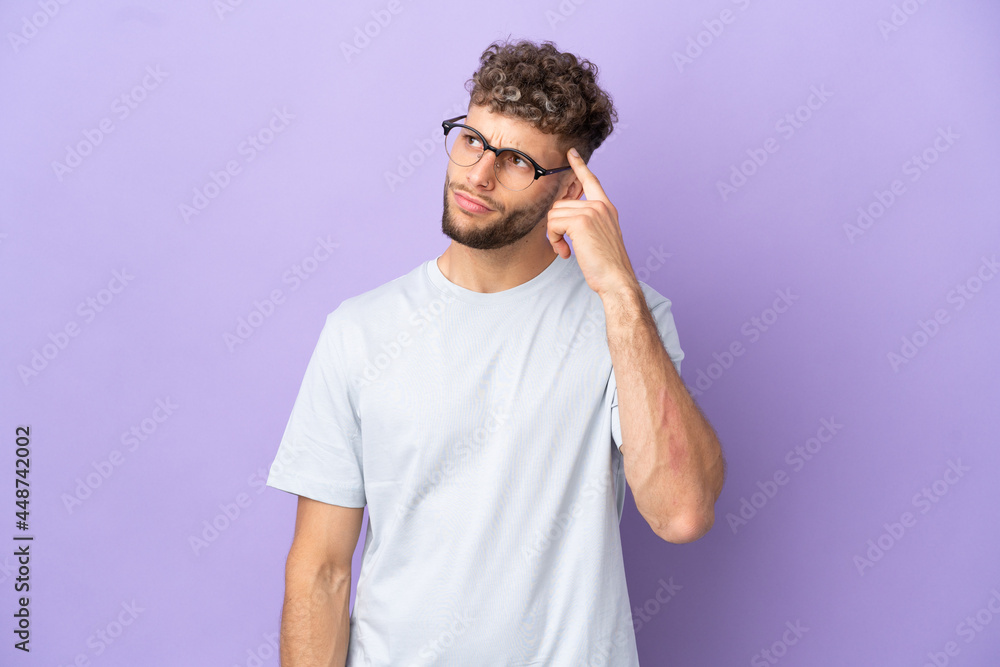 Delivery caucasian man isolated on purple background making the gesture of madness putting finger on the head Delivery caucasian man isolated on purple background making the gesture of madness putting finger on the head